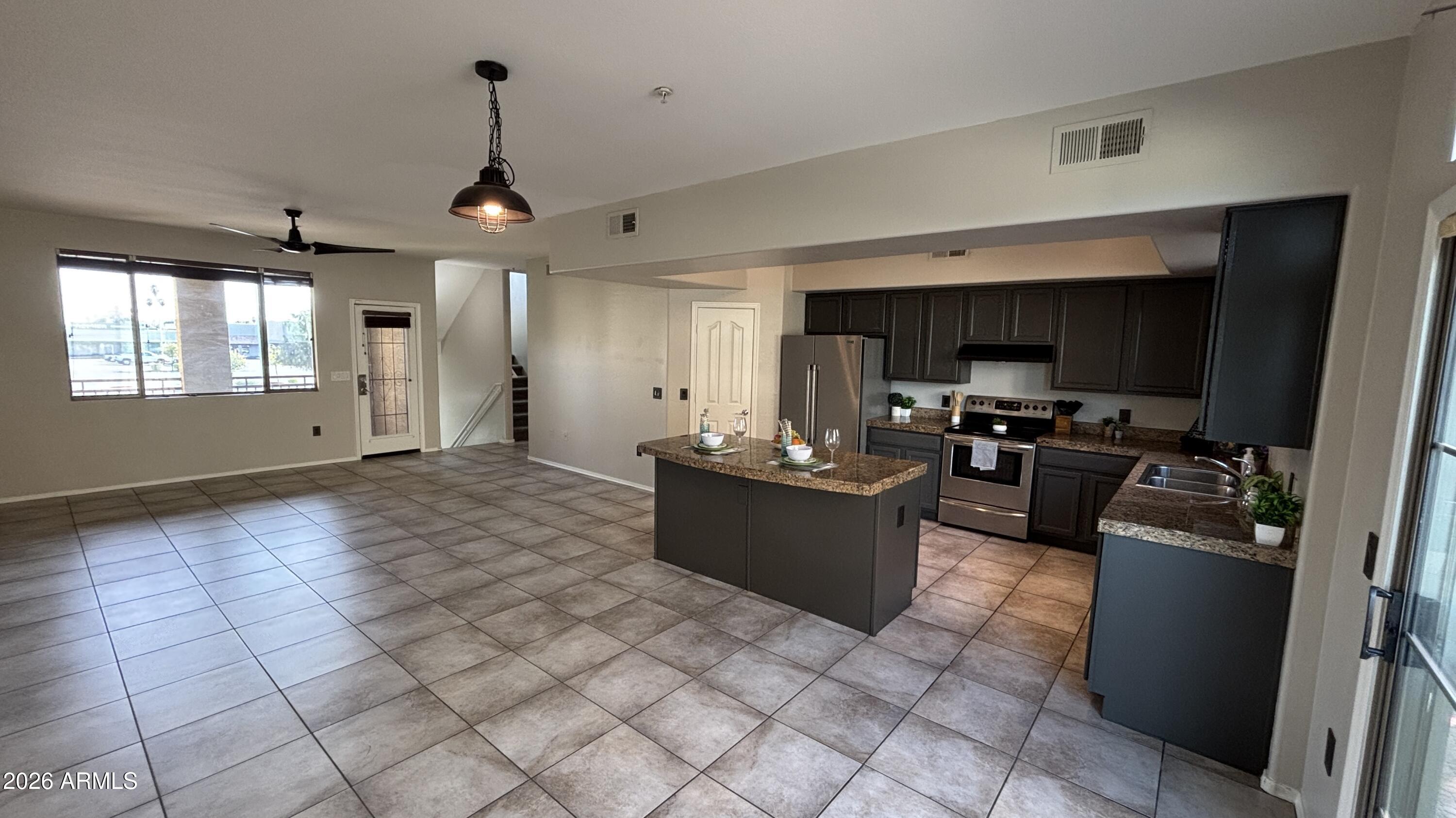 3250 West Greenway Road, Unit 104 Phoenix, AZ 85053 - Photo 6 of 26 a kitchen with stainless steel appliances granite countertop a refrigerator a sink dishwasher a stove with wooden cabinets and floor