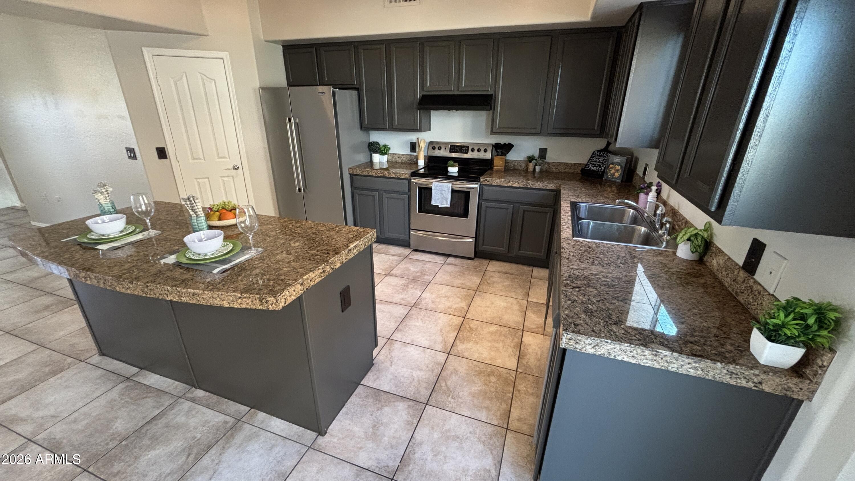 3250 West Greenway Road, Unit 104 Phoenix, AZ 85053 - Photo 8 of 26 a kitchen with stainless steel appliances granite countertop a sink stove and refrigerator