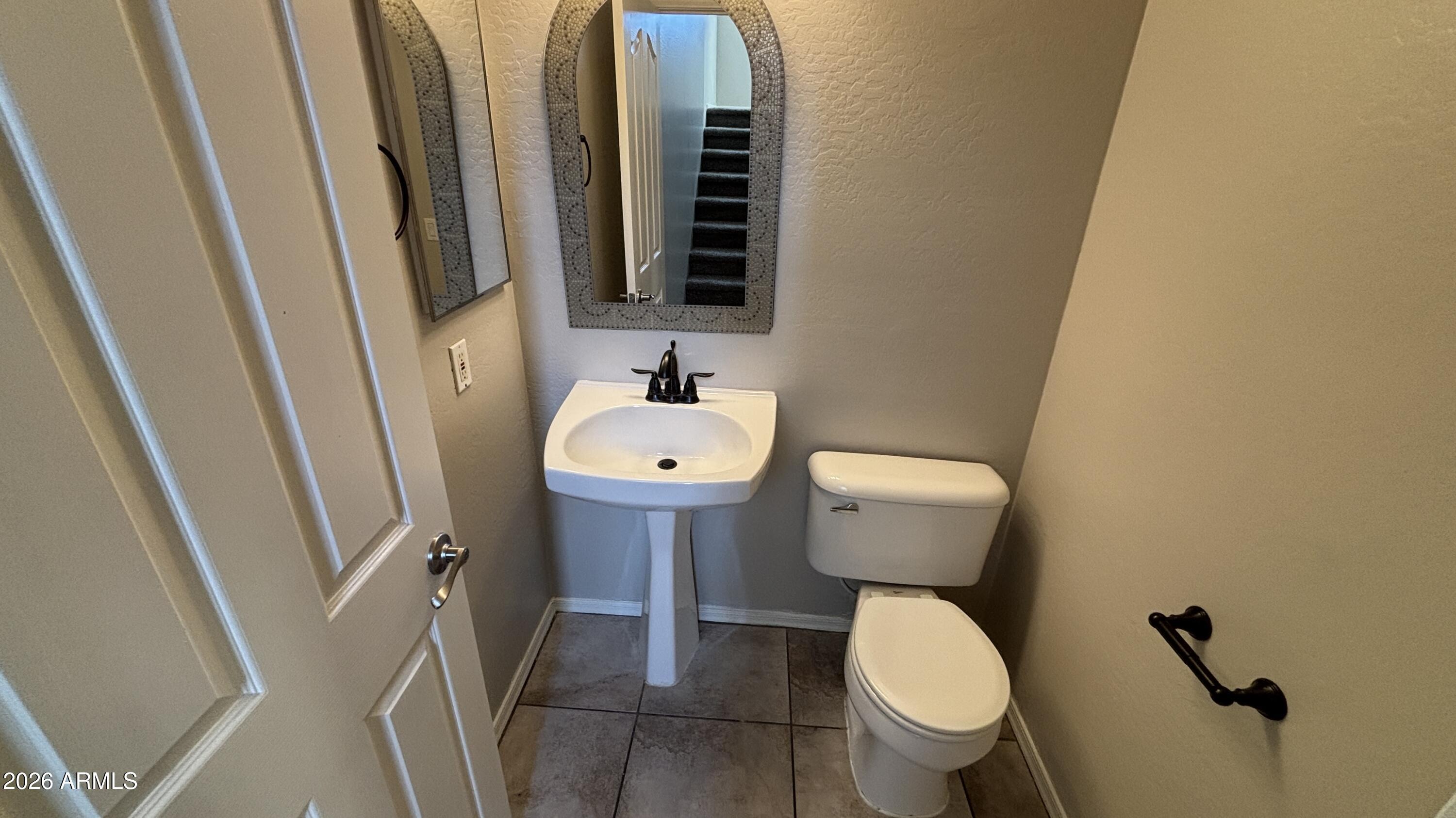 3250 West Greenway Road, Unit 104 Phoenix, AZ 85053 - Photo 10 of 26 a bathroom with a toilet and a mirror