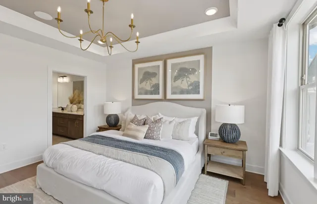 a bedroom with a large bed and a chandelier