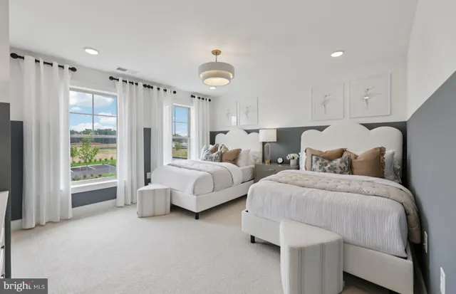 a spacious bedroom with two beds and painted walls