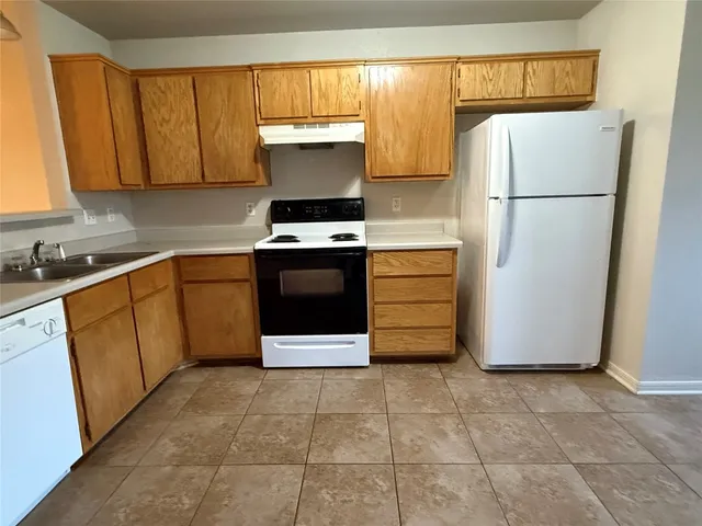 a kitchen with a stove top oven and cabinets