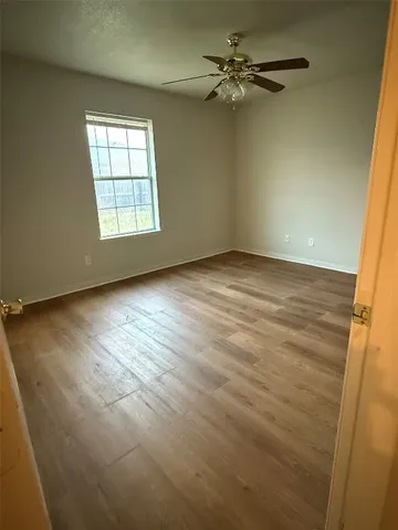 en empty room with windows and ceiling fan view