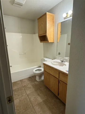 a bathroom with a granite countertop sink a toilet and mirror