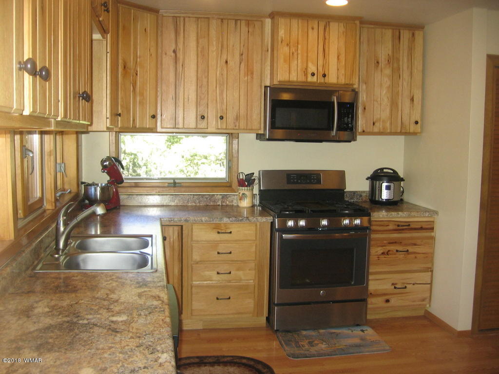 2928 Red Cinder Road Heber, AZ 85928 - Photo 20 of 38 a kitchen with granite countertop white cabinets and stainless steel appliances