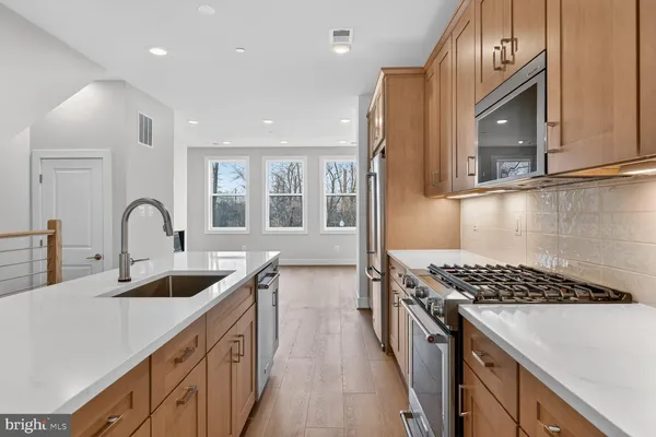 a kitchen with stainless steel appliances granite countertop a sink stove and cabinets