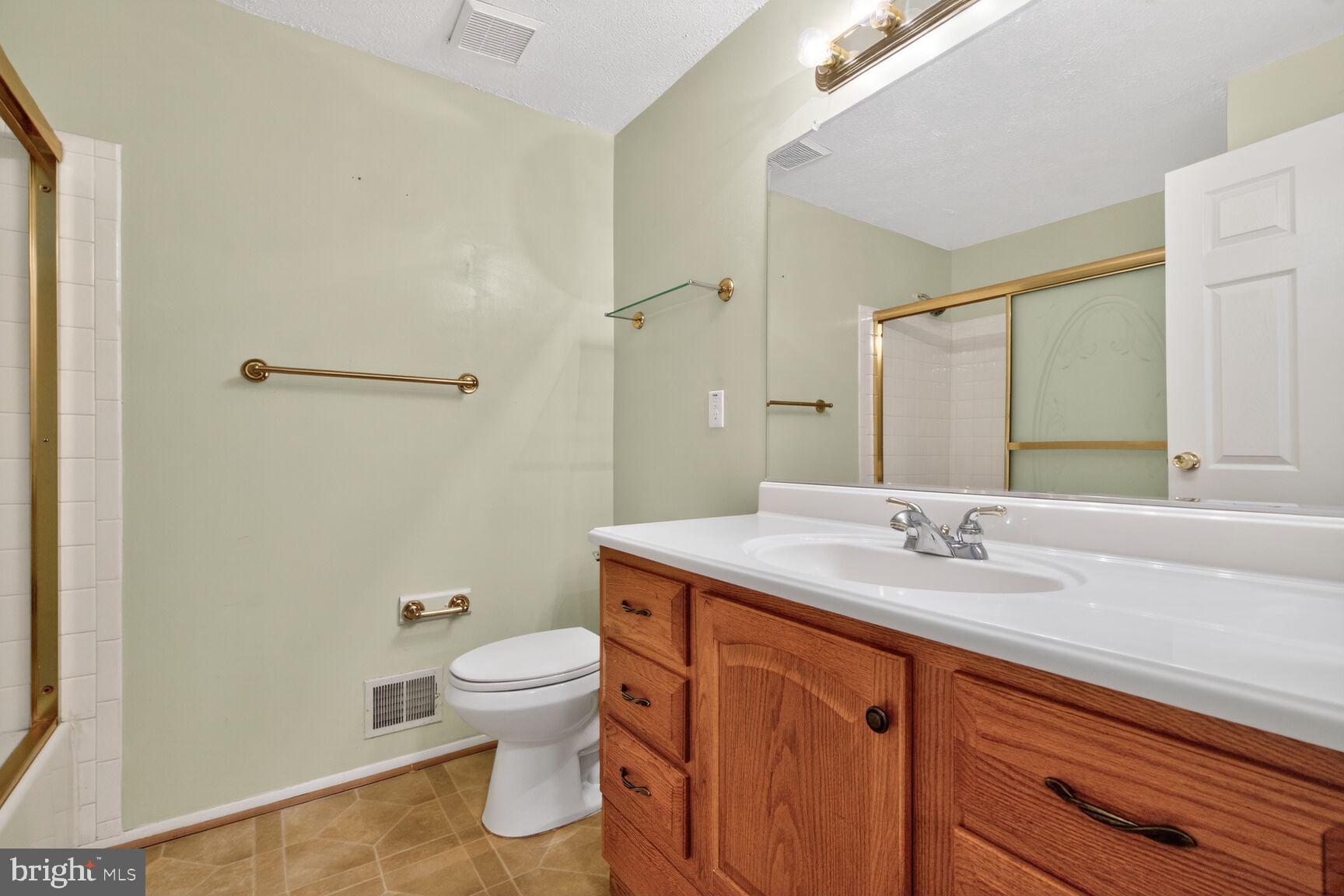 2806 Logway Road Vienna, VA 22181 - Photo 20 of 33 a bathroom with a granite countertop sink toilet and shower