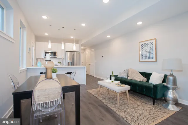 a living room with kitchen island furniture and a chandelier