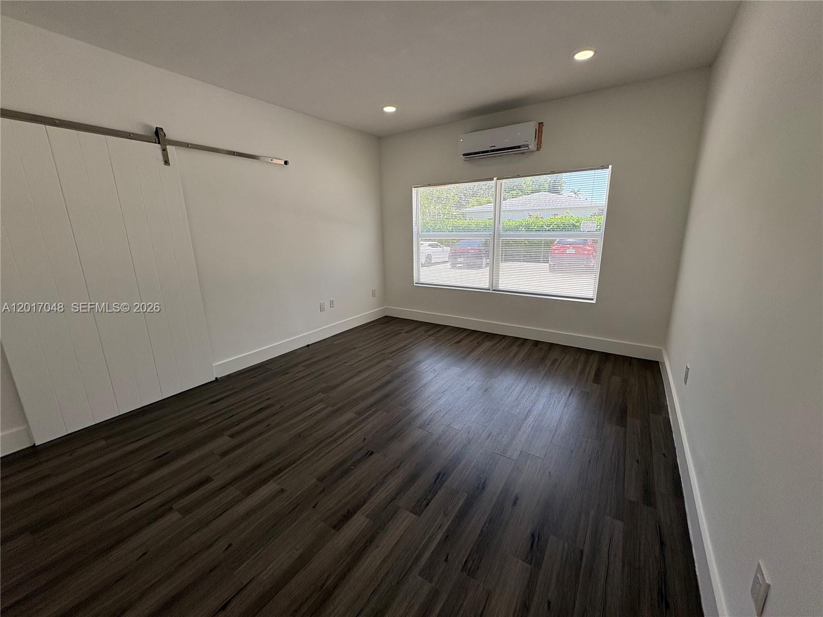 3237 Southwest 4th Street, Unit 6 Miami, FL 33135 - Photo 2 of 10 a view of an empty room with wooden floor and a window