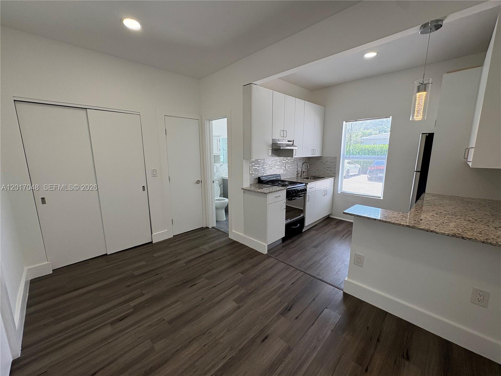 3237 Southwest 4th Street, Unit 6 Miami, FL 33135 - Photo 4 of 10 a view of a kitchen with cabinets and wooden floor