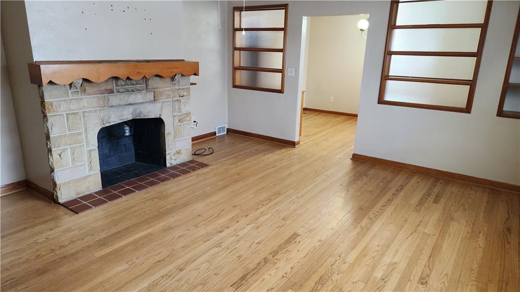 468 North Pike Road Sarver, PA 16055 - Photo 13 of 18 an empty room with wooden floor chandeliers and a fireplace