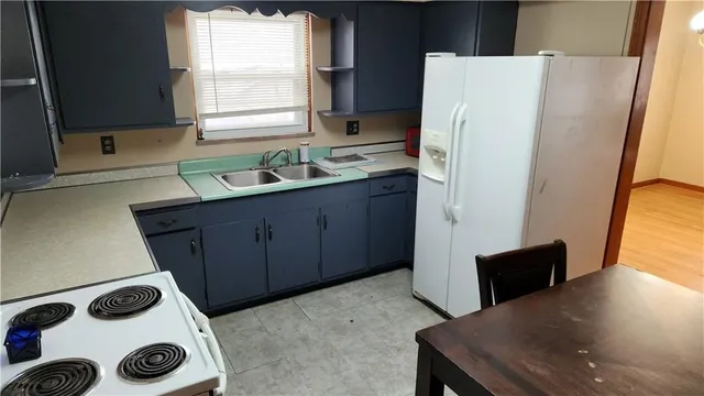 a kitchen with a refrigerator and a sink