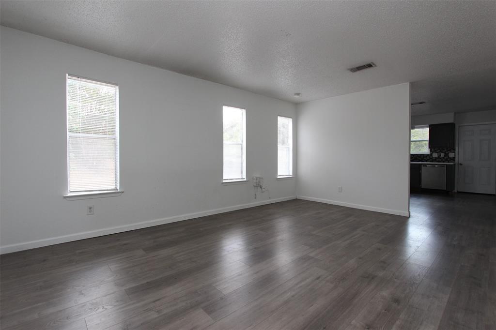 6914 Rifle Bend, Unit A Austin, TX 78736 - Photo 10 of 14 An open living space features durable wood-look flooring and multiple windows letting in natural light.