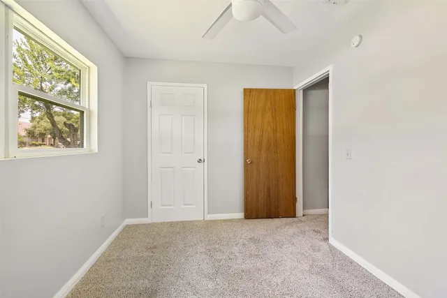 a view of an empty room with window and hallway