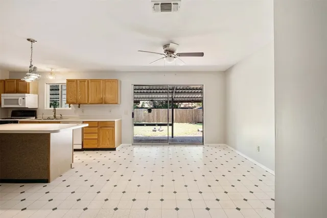 a kitchen with granite countertop a stove a sink and a refrigerator