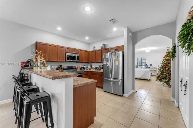 a kitchen with stainless steel appliances granite countertop a refrigerator and a stove top oven