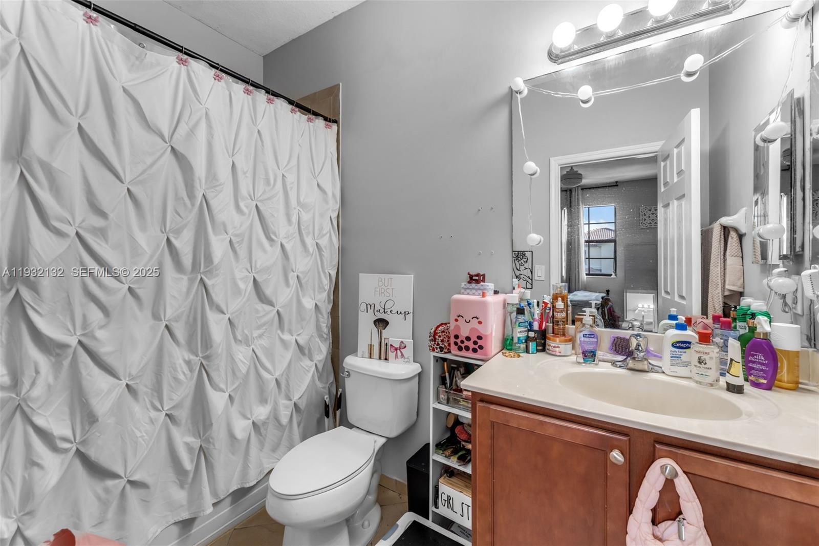22813 Southwest 88th Path Cutler Bay, FL 33190 - Photo 10 of 24 a bathroom with a sink a toilet and shower curtain