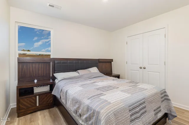 a bedroom with a bed and a painting on the wall