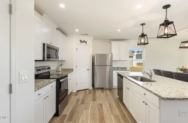 a kitchen that has a sink cabinets stainless steel appliances and a counter top space