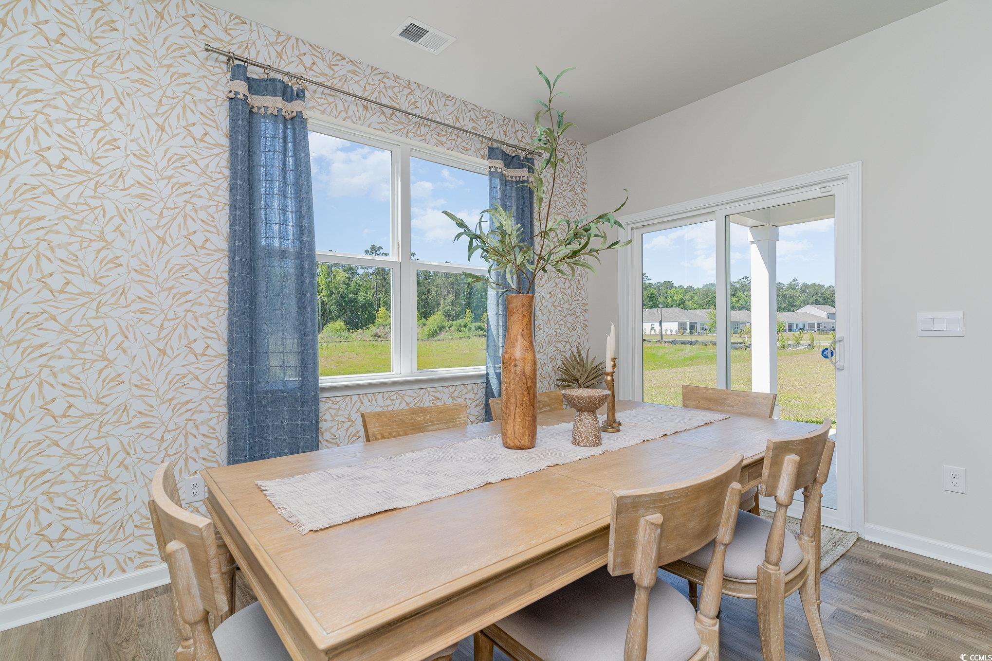 7366 Meadow Walk Loop Loris, SC 29569 - Photo 13 of 20 Dining space with wood finished floors and wallpapered walls
