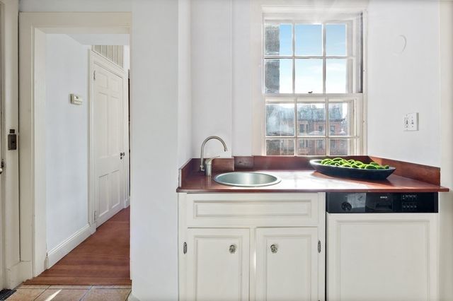 a kitchen with stainless steel appliances kitchen island granite countertop a sink cabinets and wooden floor