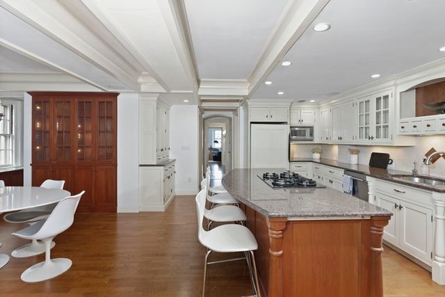 a dining room with wooden floor a chandelier a wooden table and chairs