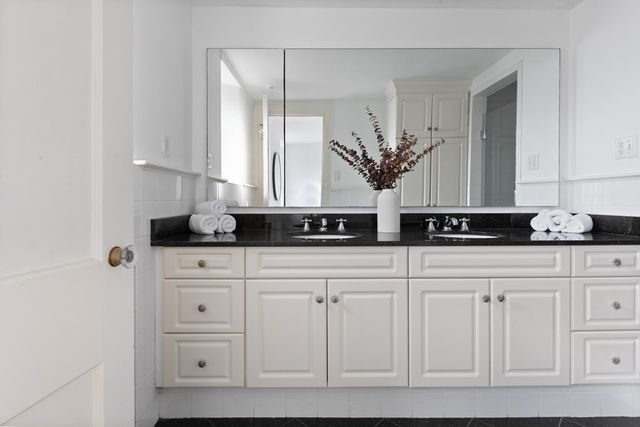 a bathroom with a granite countertop sink a mirror and shower