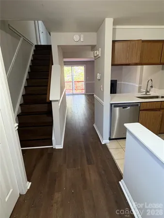 a view of entryway and kitchen with wooden floor