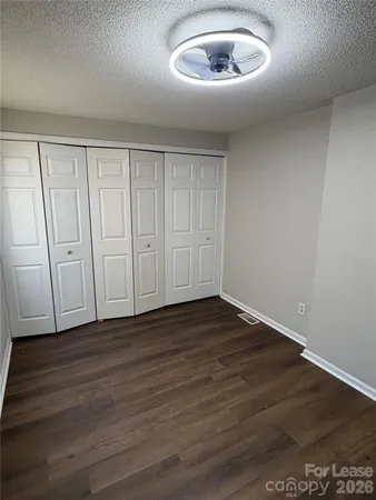a view of an empty room with wooden floor closet