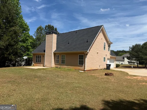 a backyard of a house with table and chairs
