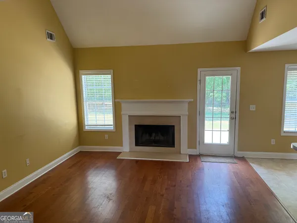 a view of an empty room with a fireplace and a window