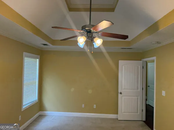 a view of a livingroom with a chandelier fan and a window