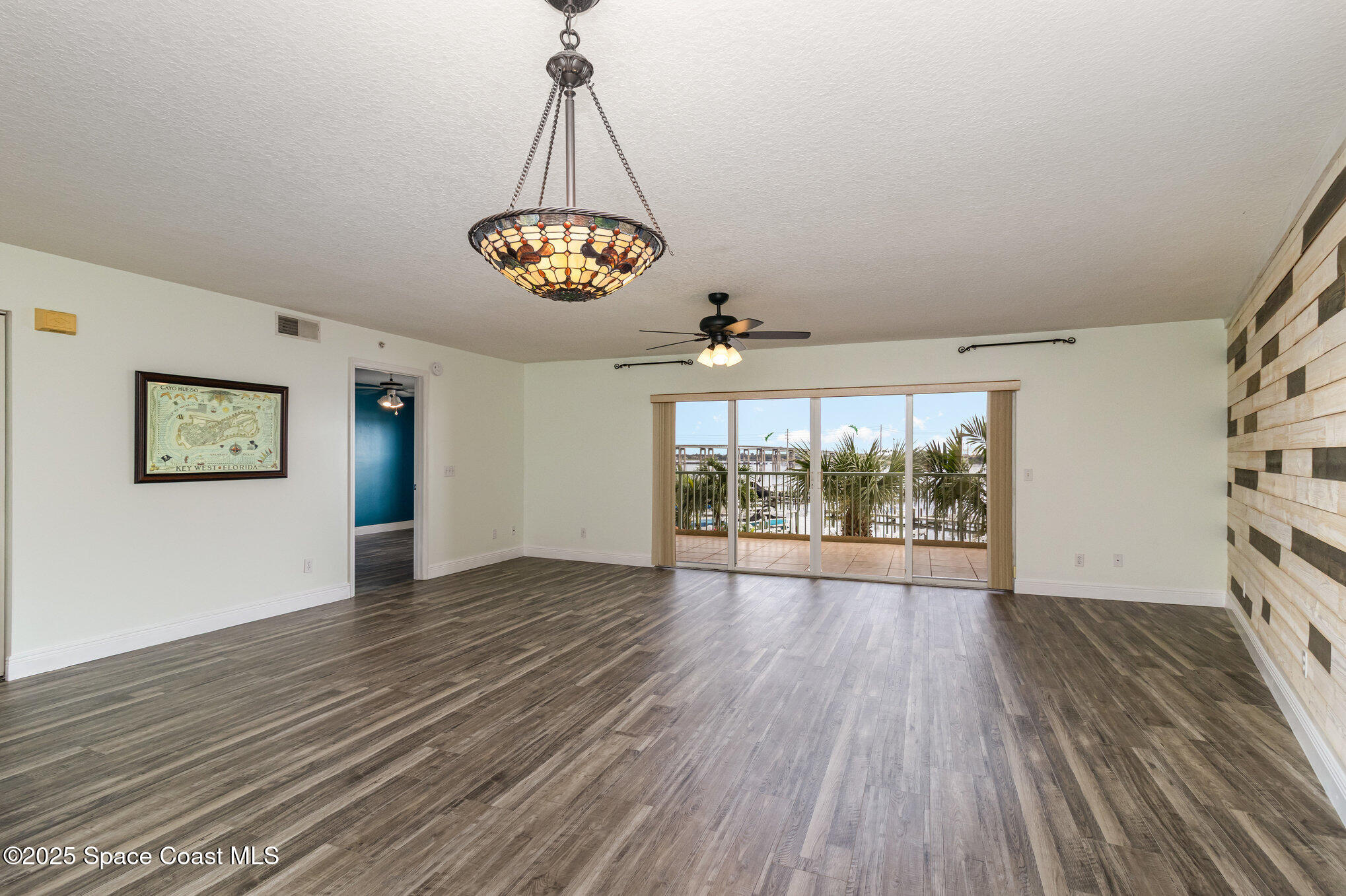 102 Riverside Drive, Unit 203 Cocoa, FL 32922 - Photo 3 of 26 an empty room with wooden floor and windows