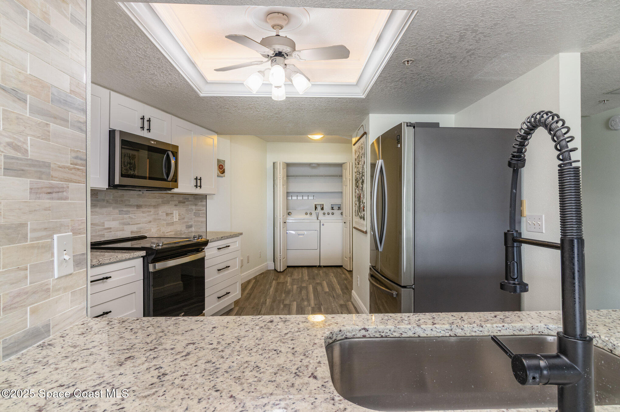 102 Riverside Drive, Unit 203 Cocoa, FL 32922 - Photo 5 of 26 a kitchen with stainless steel appliances kitchen island granite countertop a refrigerator a sink a stove with cabinets