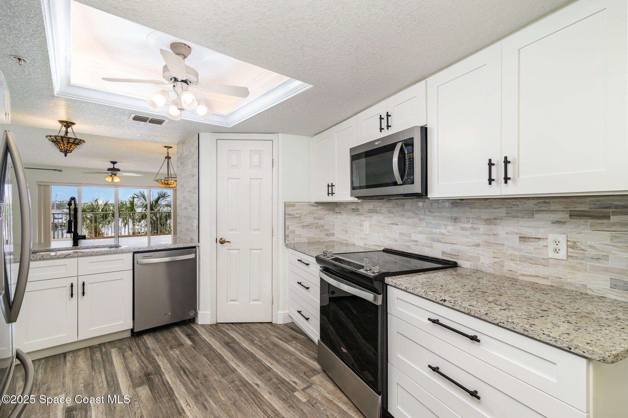 102 Riverside Drive, Unit 203 Cocoa, FL 32922 - Photo 6 of 26 a kitchen with granite countertop cabinets stainless steel appliances and a counter space