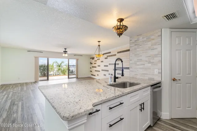 a kitchen with a sink and a large mirror