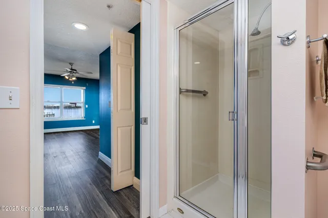 a view of a hallway with wooden floor windows and a living room