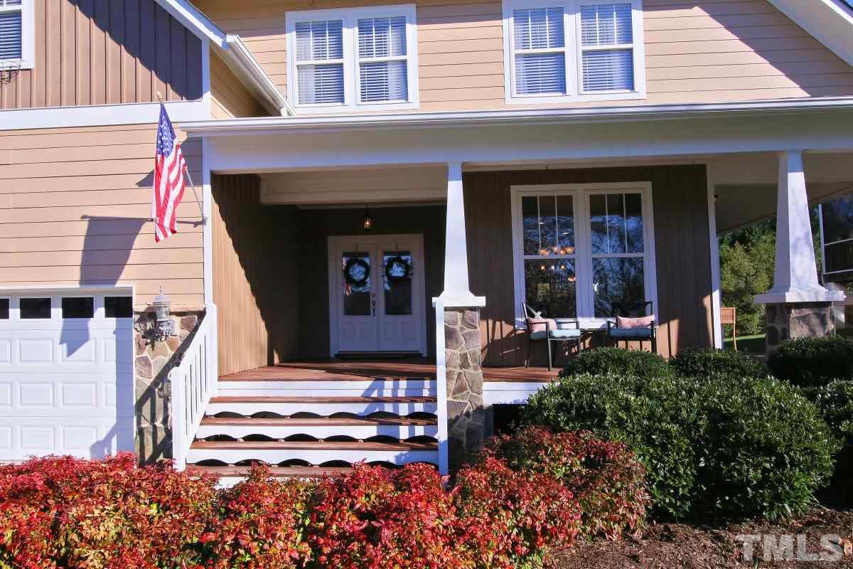 1128 Coram Fields Road Wake Forest, NC 27587 - Photo 2 of 25 Enjoy this lovely wrap around front porch featuring extra wide welcoming stairs, Stone columns and double entry doors.