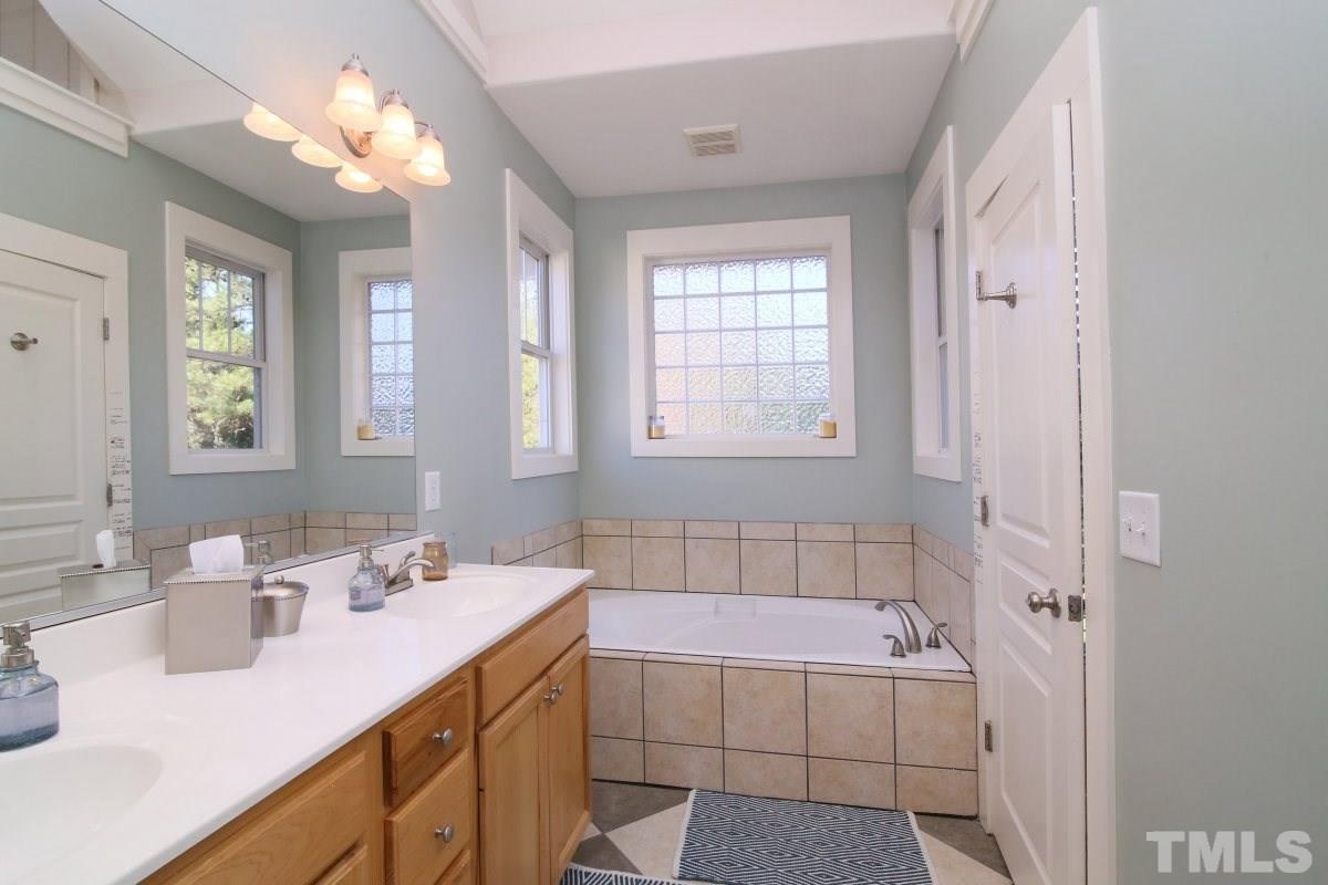 1128 Coram Fields Road Wake Forest, NC 27587 - Photo 14 of 25 Master bath features and large tub, double vanity, separate shower, tile floors & separate toilet room.