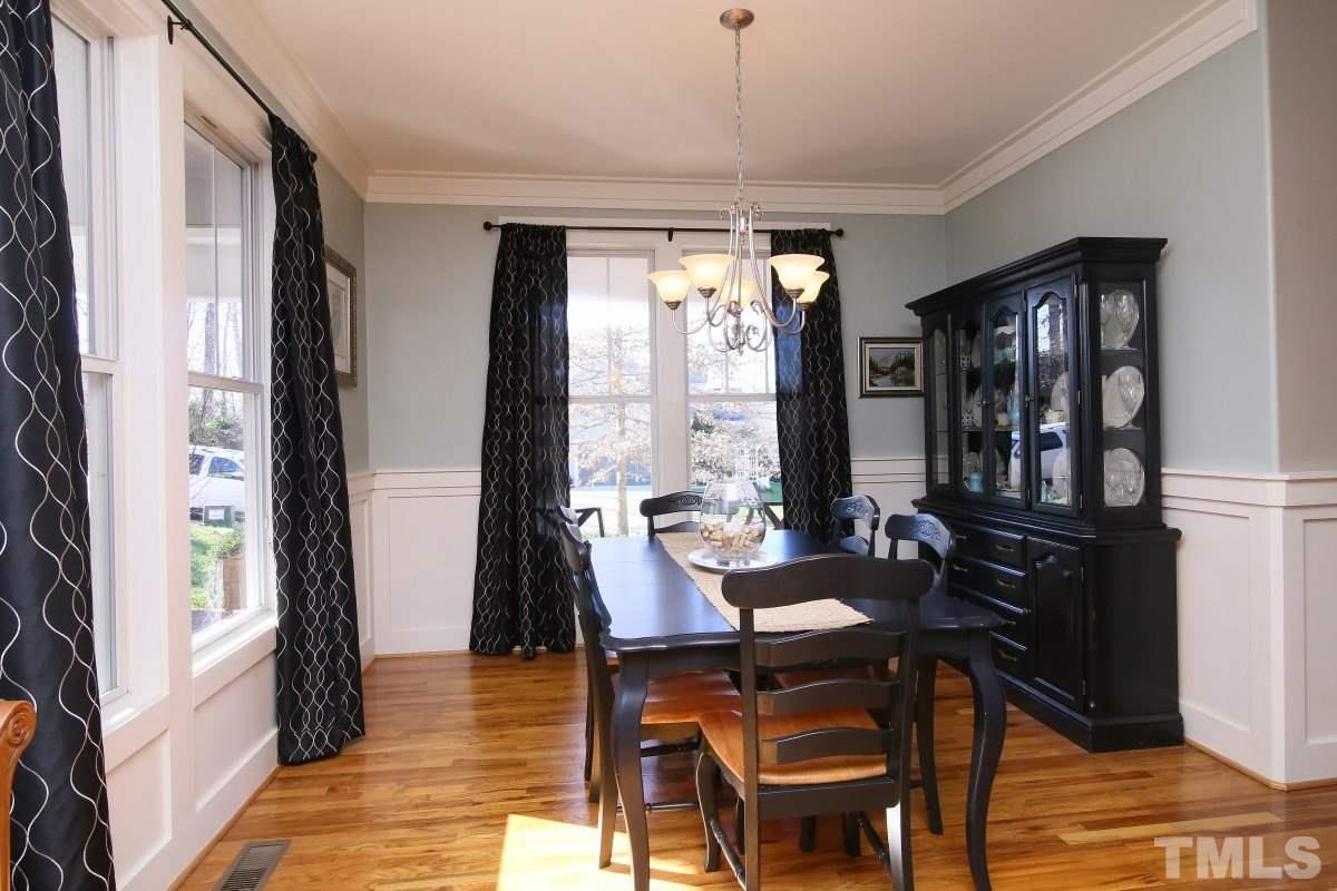 1128 Coram Fields Road Wake Forest, NC 27587 - Photo 7 of 25 This lovely dining room features, gorgeous crown molding, wainscoting, pretty big windows, hardwoods and a modern chandelier.