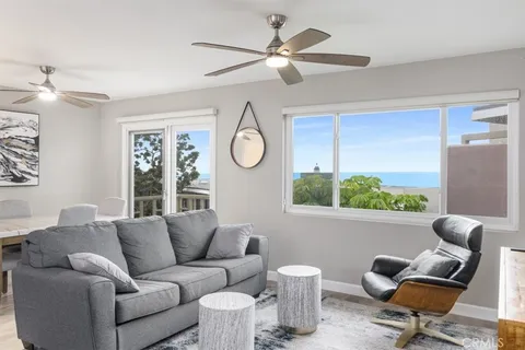 a living room with furniture a ceiling fan and a window