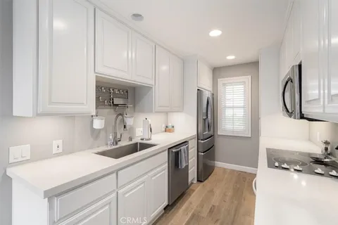 a kitchen with kitchen island granite countertop a sink stainless steel appliances and cabinets