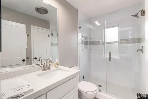 a bathroom with a sink toilet vanity and shower
