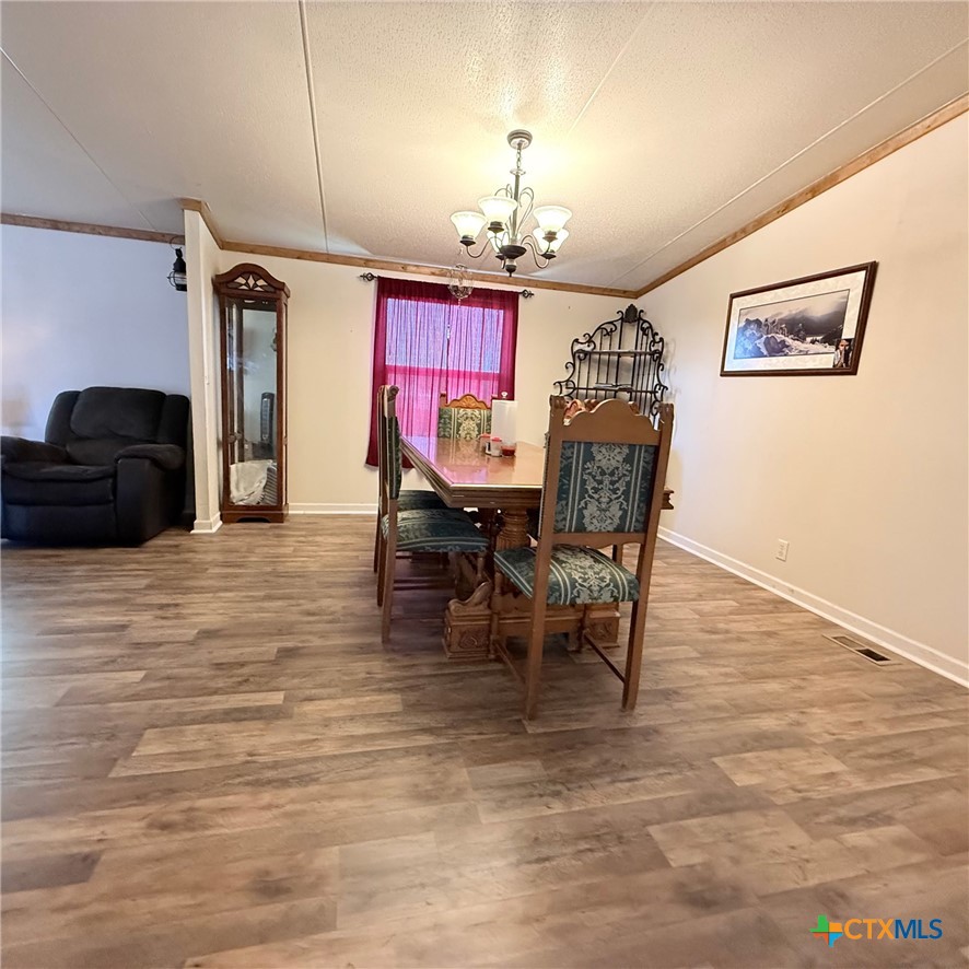 850 Blakely Road Gatesville, TX 76528 - Photo 24 of 32 a dining room with furniture a chandelier and wooden floor