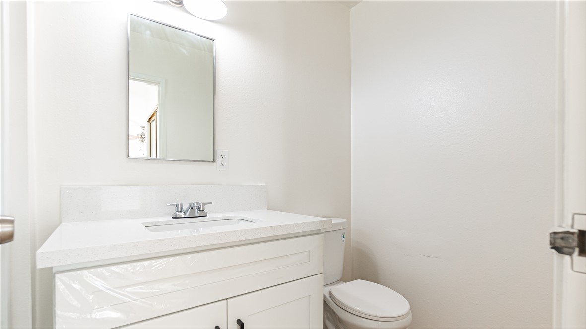 9293 Guava Avenue Hesperia, CA 92345 - Photo 19 of 32 a bathroom with a toilet sink vanity and mirror
