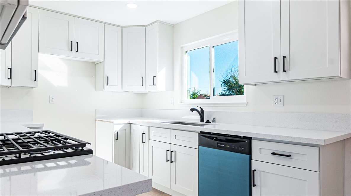 9293 Guava Avenue Hesperia, CA 92345 - Photo 7 of 32 a kitchen with white cabinets and appliances