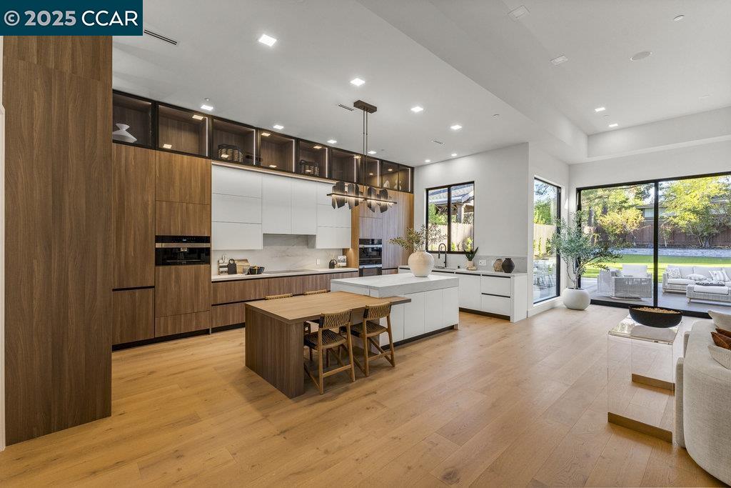 a kitchen with kitchen island a large counter top space a sink stainless steel appliances and cabinets