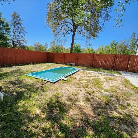 a view of a yard with wooden fence