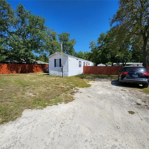 a view of a house with backyard and trees
