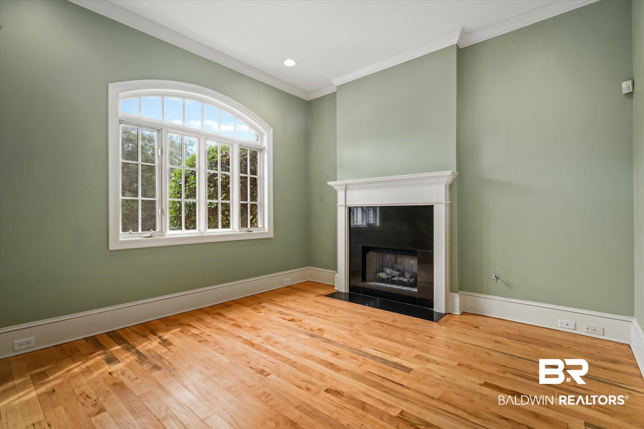 812 Country Club Court Mobile, AL 36609 - Photo 4 of 34 Unfurnished living room featuring crown molding, wood-type flooring, and a fireplace